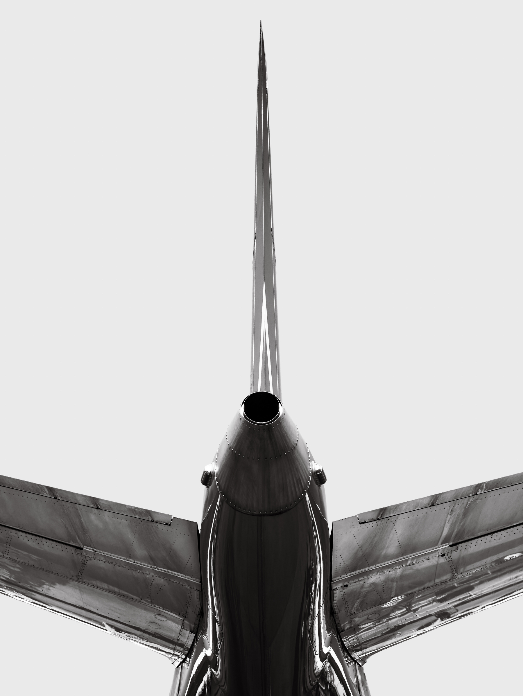 Auto-generated description: A black and white image featuring the rear view of a sleek, modern airplane with its tail fin prominently displayed.
